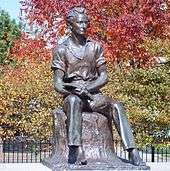 statue of young Lincoln sitting on a stump, holding a book open on 