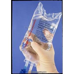  Gloved hand holding an intravenous drip bag Photographic 